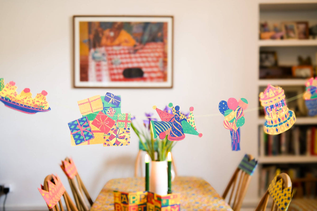 Colorful East End Press sewn garland displayed across a dining room for a birthday celebration