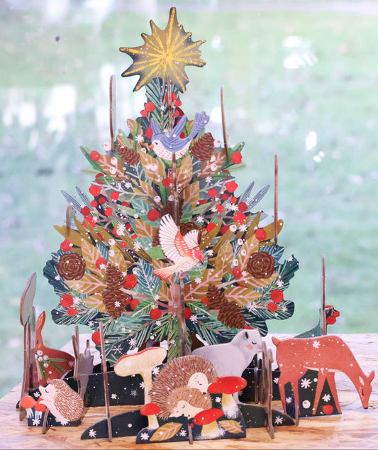Fully assembled Antoana Oreski Beneath the Tree Pop & Slot Advent Calendar displayed as a three-dimensional Christmas tree surrounded by woodland animals, birds, mushrooms, and festive forest details.