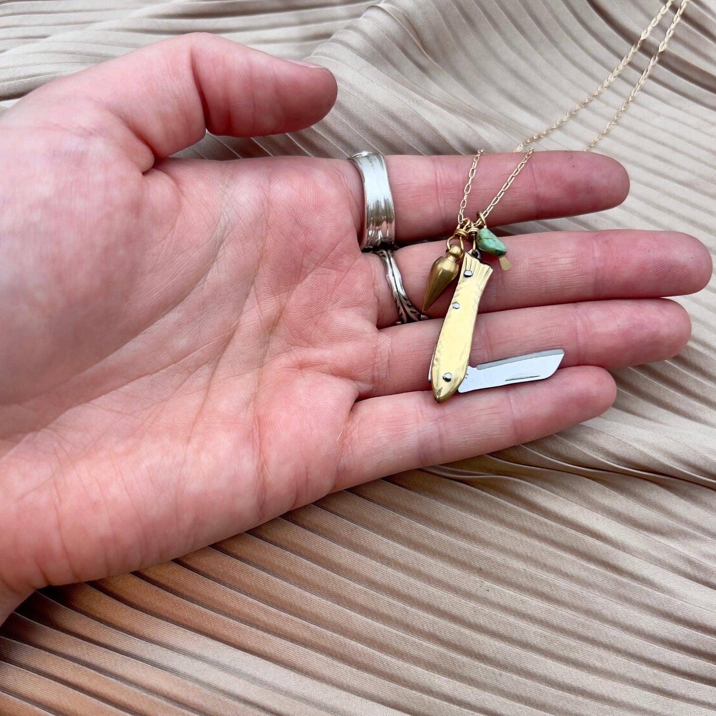 feeesh knife necklace, fish knife pendant, mini knife necklace, pocket knife necklace for women, functional fish knife jewelry, turquoise bullet charm necklace, rogue style necklace, campfire necklace with blade, fishing knife pendant, everyday carry necklace, catch and release jewelry, tiny blade necklace, adventurer pocket knife jewelry, quirky knife necklace, real mini knife pendant