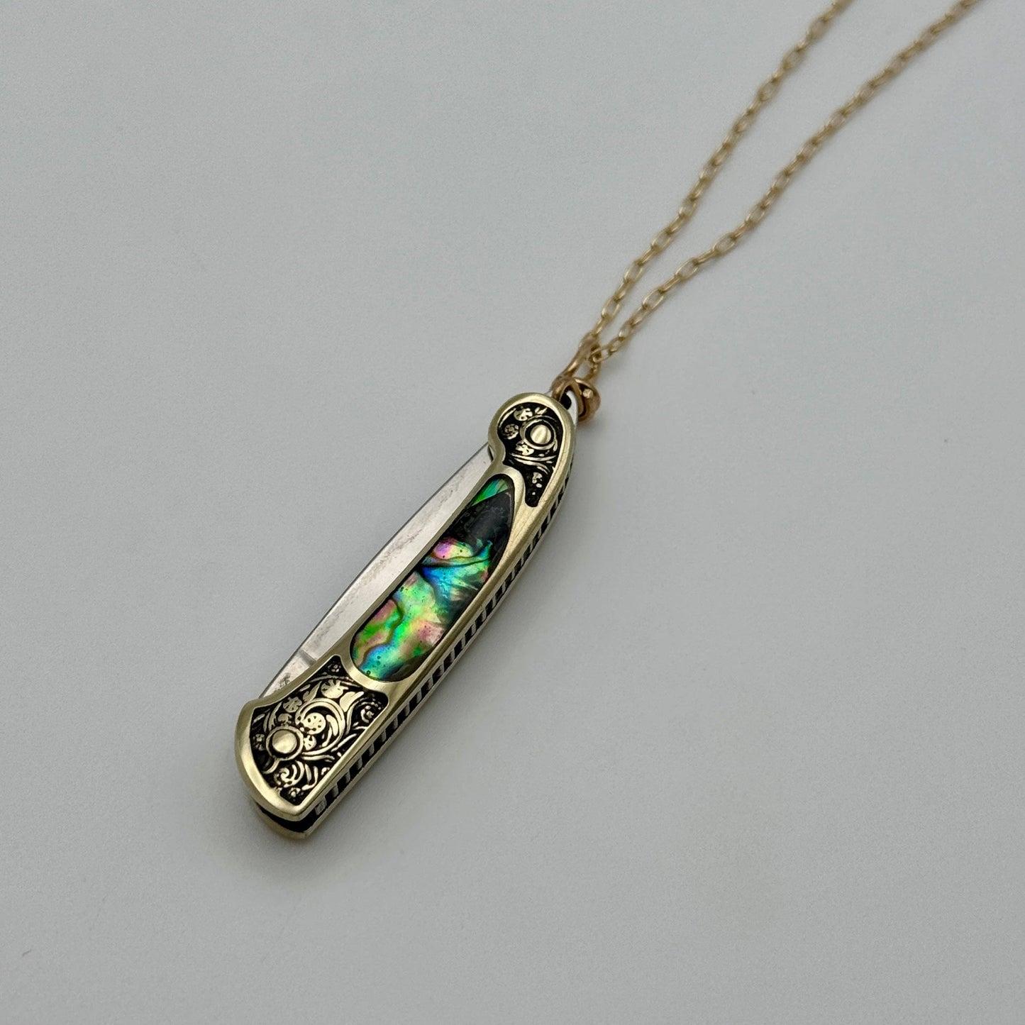 lennox necklace knife, mini knife necklace gold, abalone pocket knife jewelry, stealthy knife pendant, gold filled knife necklace, functional knife jewelry, filigree knife necklace, vintage inspired utility necklace, pocket knife necklace for women, adventurer jewelry, abalone shell pendant knife, necklace with hidden blade, fashionable self defense necklace, secret blade necklace, gold mini knife pendant