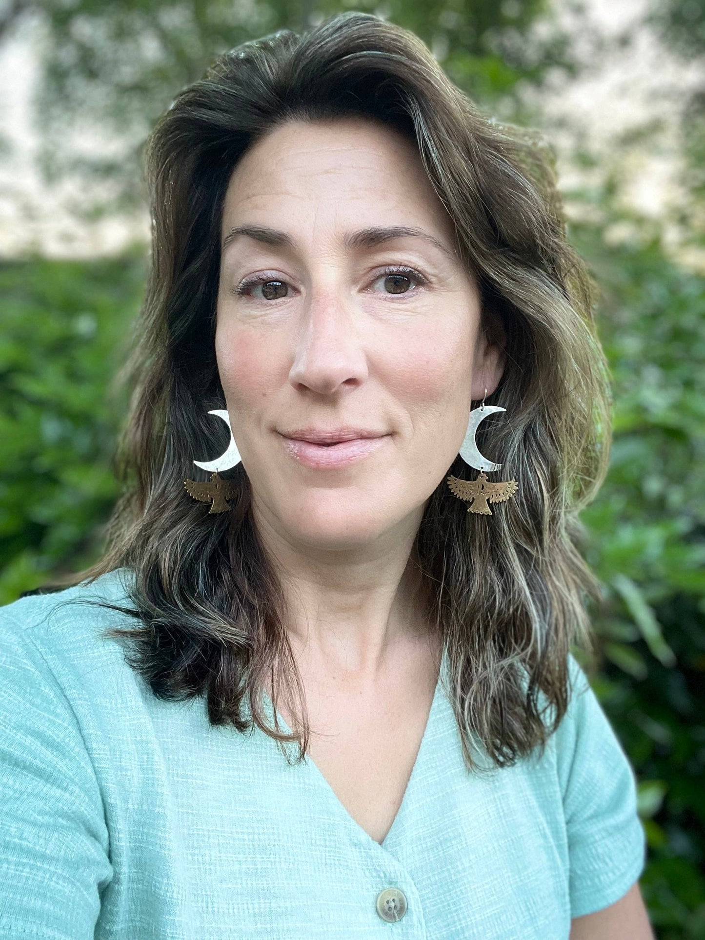 Fluff Hardware Night Wing Earrings are handcrafted mixed-metal statement earrings featuring an outstretched bird suspended beneath a crescent moon. Finished with hypoallergenic sterling silver ear wires, these vintage-meets-nature earrings bring elegant movement and a subtle hint of wildness to everyday outfits. A meaningful small-batch gift for lovers of celestial jewelry, bird motifs, and story-driven design.