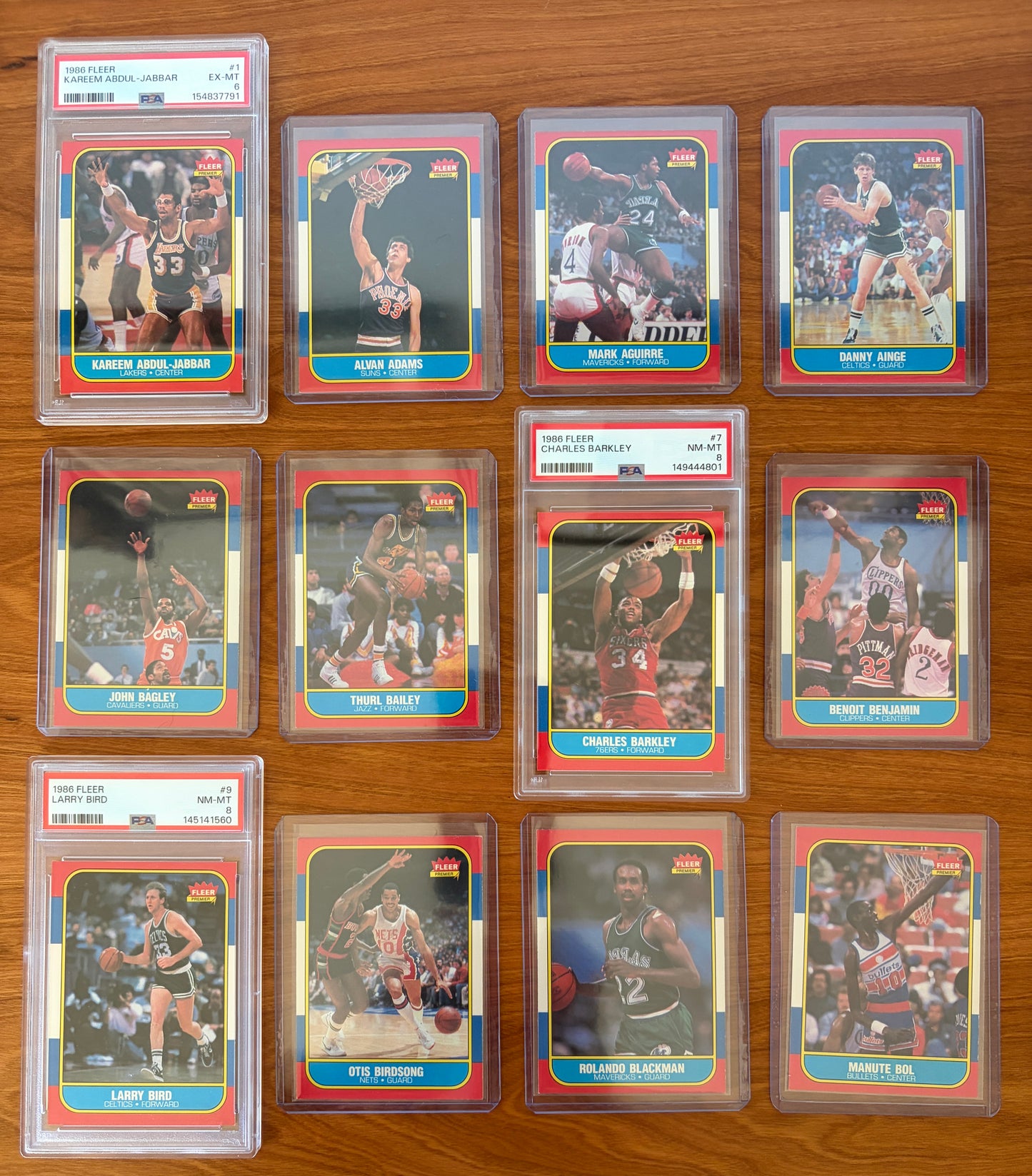 1986 Fleer Basketball cards #1–12 displayed from the complete 1986–87 Fleer Basketball set. Featured graded cards include Kareem Abdul-Jabbar #1 PSA 6, Charles Barkley rookie card #7 PSA 8, and Larry Bird #9 PSA 8. Also shown are Alvan Adams #2, Mark Aguirre #3, Danny Ainge #4, John Bagley #5, Thurl Bailey #6, Benoit Benjamin #8, Otis Birdsong #10, Rolando Blackman #11, and Manute Bol #12. Part of the iconic 1986 Fleer Basketball release.