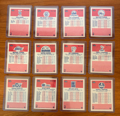 Backs of 1986 Fleer Basketball cards #13–24 displayed from the complete 1986–87 Fleer Basketball set. Featured players include Sam Bowie #13, Joe Barry Carroll #14, Tom Chambers #15, Maurice Cheeks #16, Michael Cooper #17, Wayne Cooper #18, Pat Cummings #19, Terry Cummings #20, Adrian Dantley #21, Brad Davis #22, Walter Davis #23, and Darryl Dawkins #24. The card backs display player statistics, biographical information, and team logos from the iconic 1986 Fleer Basketball release.