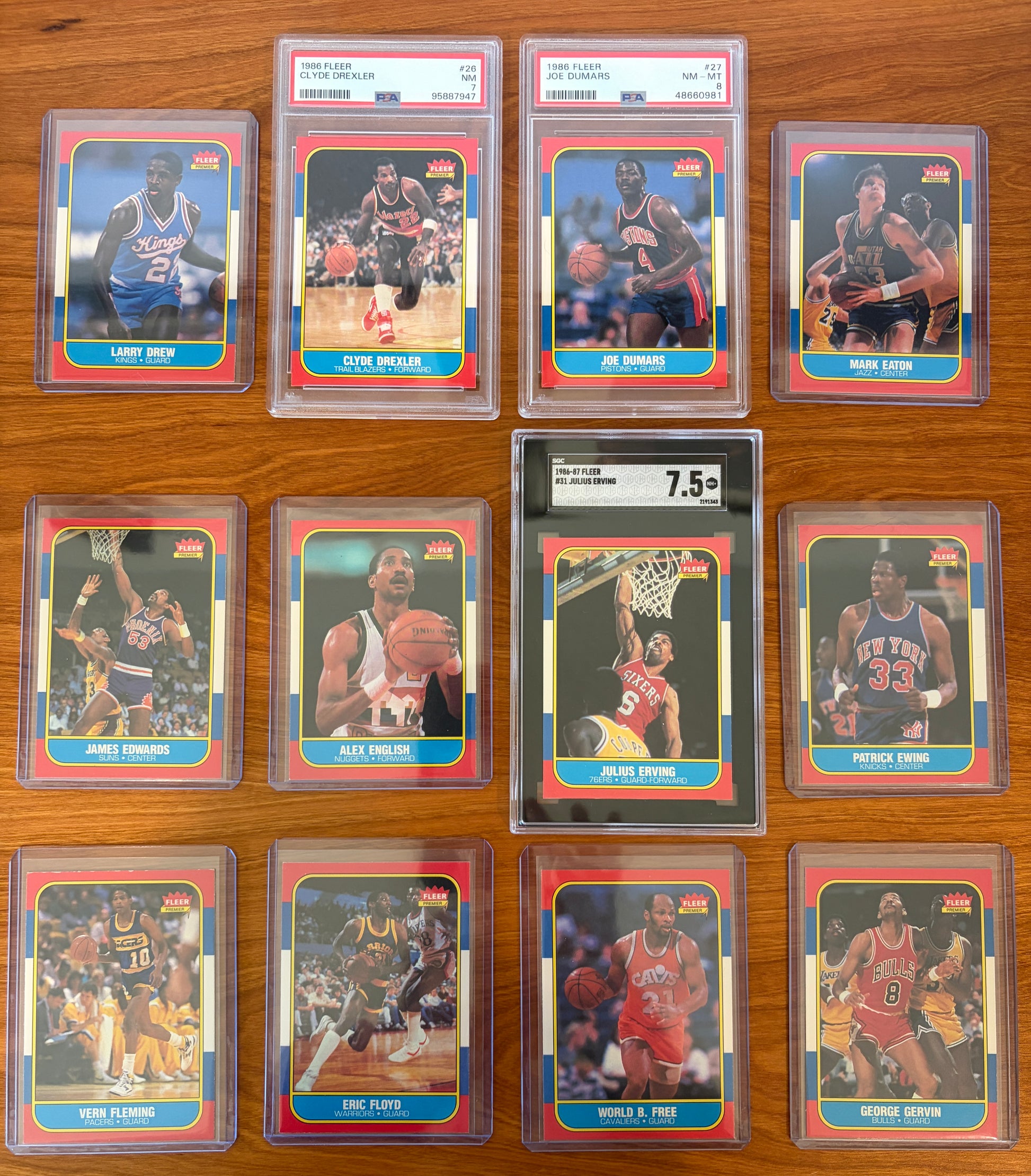 Fronts of 1986 Fleer Basketball cards #25–36 displayed from the complete 1986–87 Fleer Basketball set. Featured players include Larry Drew #25, PSA-graded Clyde Drexler #26, PSA-graded Joe Dumars #27, Mark Eaton #28, James Edwards #29, Alex English #30, SGC-graded Julius Erving #31, Patrick Ewing #32, Vern Fleming #33, Eric Floyd #34, World B. Free #35, and George Gervin #36. Key Hall of Famers Drexler, Erving, Ewing, Dumars, English, and Gervin are included in this section of the iconic 1986 Fleer Basketba