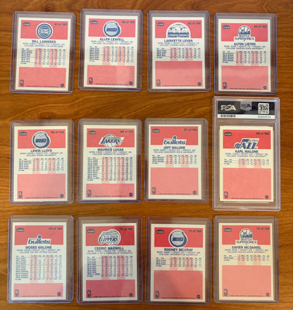 Backs of 1986 Fleer Basketball cards #61–72 from the complete 1986–87 Fleer Basketball set. Includes Bill Laimbeer #61, Allen Leavell #62, Lafayette Lever #63, Alton Lister #64, Lewis Lloyd #65, Maurice Lucas #66, Jeff Malone #67, PSA-graded Karl Malone rookie card #68, Moses Malone #69, Cedric Maxwell #70, Rodney McCray #71, and Xavier McDaniel #72. Card backs display player statistics, biographical information, and team logos from the iconic 1986 Fleer Basketball release.