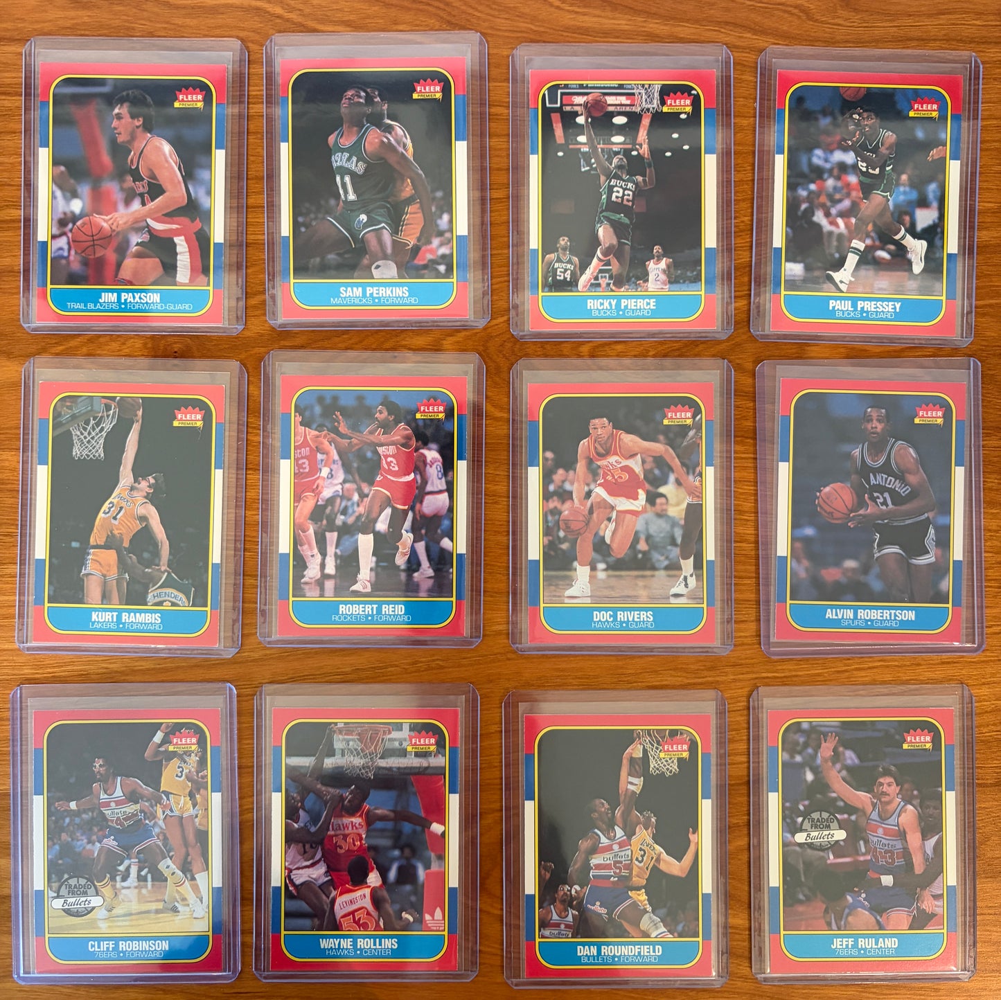 1986 Fleer Basketball cards #85–96 displayed from the complete 1986–87 Fleer Basketball set. Featured players include Jim Paxson #85, Sam Perkins #86, Ricky Pierce #87, Paul Pressey #88, Kurt Rambis #89, Robert Reid #90, Doc Rivers #91, Alvin Robertson #92, Cliff Robinson #93, Wayne Rollins #94, Dan Roundfield #95, and Jeff Ruland #96. Part of the iconic 1986 Fleer Basketball release.