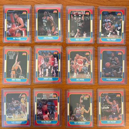 1986 Fleer Basketball cards #85–96 displayed from the complete 1986–87 Fleer Basketball set. Featured players include Jim Paxson #85, Sam Perkins #86, Ricky Pierce #87, Paul Pressey #88, Kurt Rambis #89, Robert Reid #90, Doc Rivers #91, Alvin Robertson #92, Cliff Robinson #93, Wayne Rollins #94, Dan Roundfield #95, and Jeff Ruland #96. Part of the iconic 1986 Fleer Basketball release.