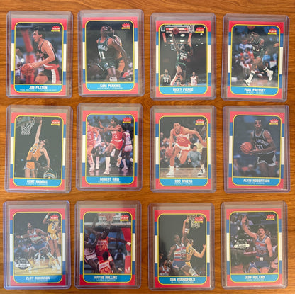 1986 Fleer Basketball cards #85–96 displayed from the complete 1986–87 Fleer Basketball set. Featured players include Jim Paxson #85, Sam Perkins #86, Ricky Pierce #87, Paul Pressey #88, Kurt Rambis #89, Robert Reid #90, Doc Rivers #91, Alvin Robertson #92, Cliff Robinson #93, Wayne Rollins #94, Dan Roundfield #95, and Jeff Ruland #96. Part of the iconic 1986 Fleer Basketball release.