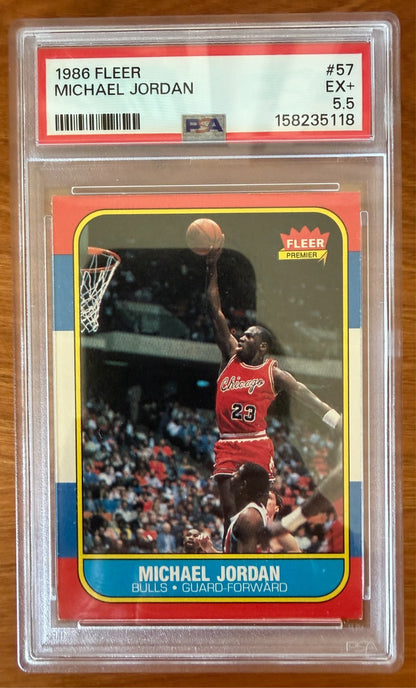 1986 Fleer Michael Jordan rookie card #57 graded PSA 5.5 (EX+). The iconic card features Jordan in a Chicago Bulls uniform soaring toward the basket for a one-handed dunk. Widely regarded as one of the most important basketball rookie cards ever produced, the card is encapsulated in an authenticated PSA holder.