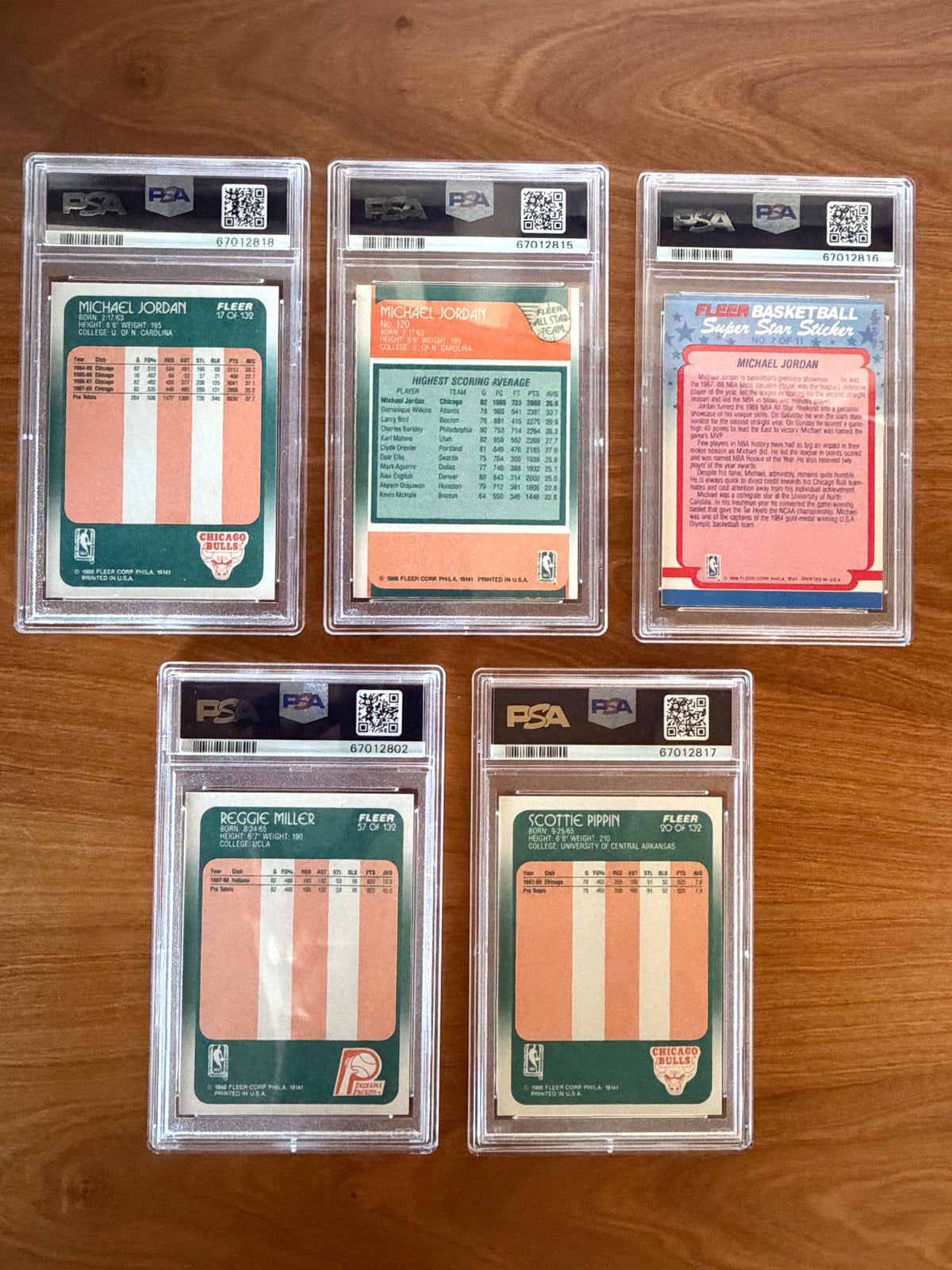 Reverse sides of the PSA-graded Michael Jordan, Scottie Pippen rookie, and Reggie Miller rookie cards.