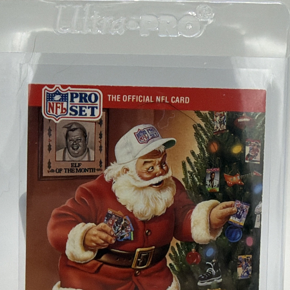 Close-up of Santa Claus in a red suit beside Christmas decorations and presents