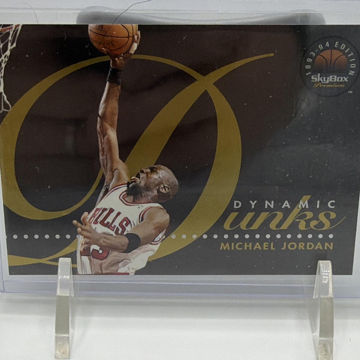 Angled photograph of 1993–94 SkyBox Premium Dynamic Dunks Michael Jordan basketball insert in protective holder