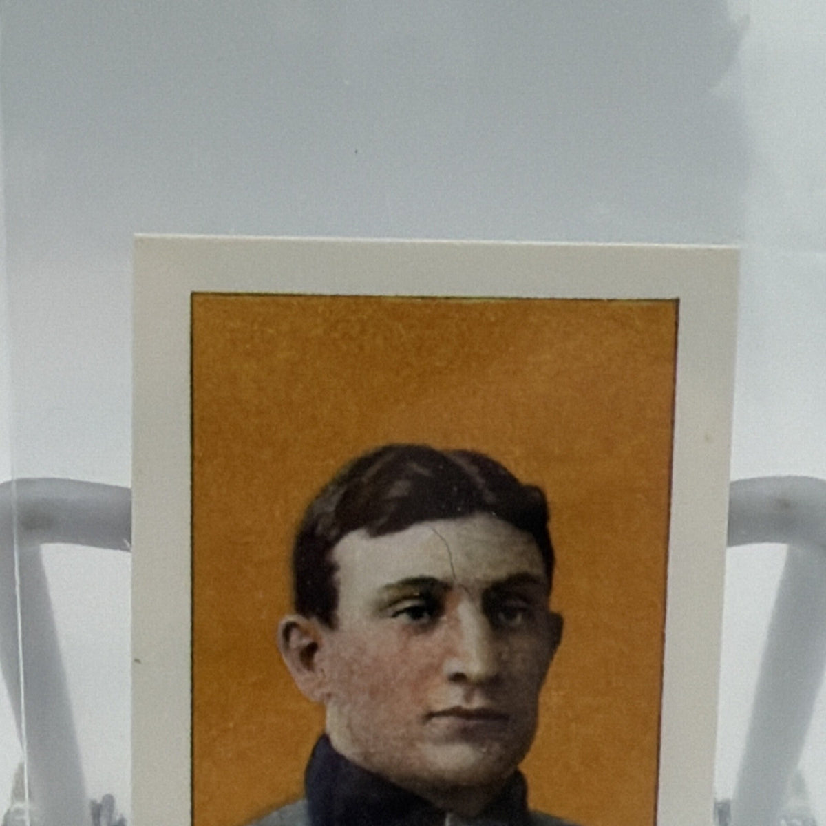 Close-up of Honus Wagner portrait against orange background on commemorative baseball card