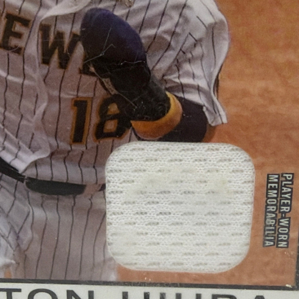 Close-up of white fabric memorabilia swatch embedded in Keston Hiura 2021 Topps baseball relic card