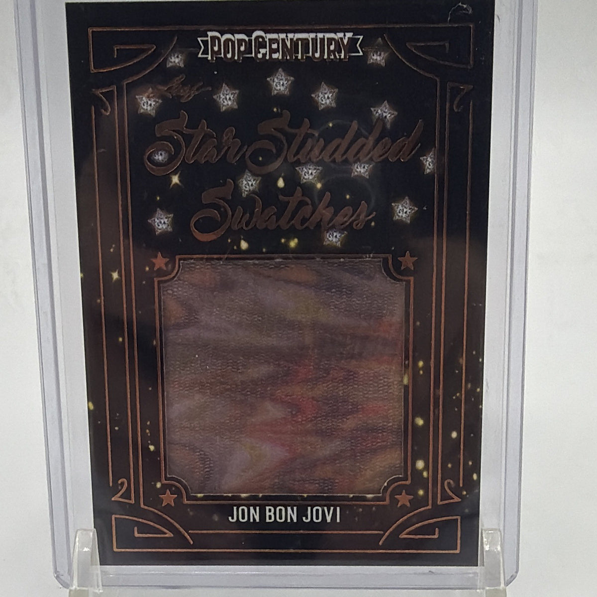Front of 2022 Leaf Pop Century Jon Bon Jovi Star-Studded Swatches #SS-JBJ with colorful worn memorabilia