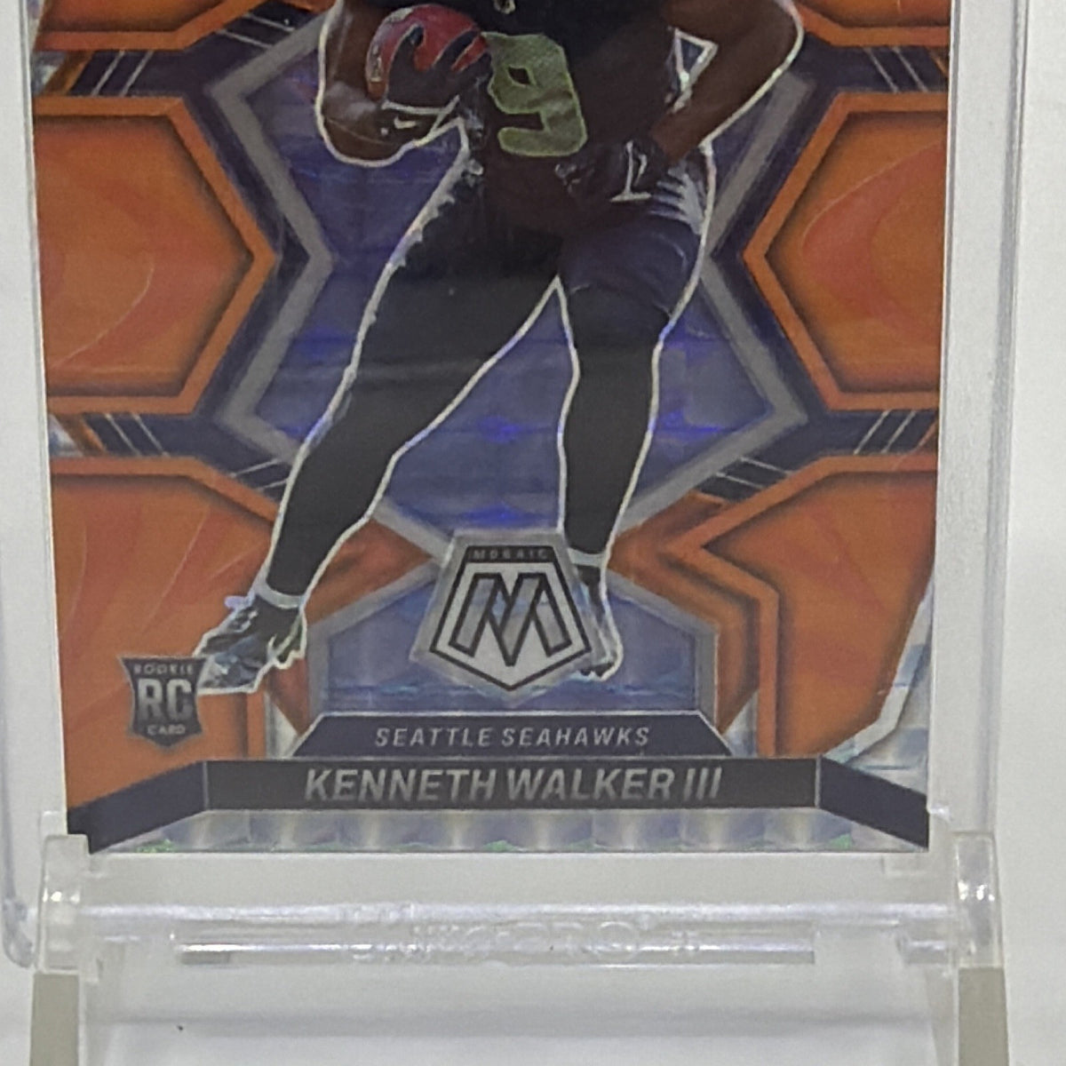 Angled front view of Kenneth Walker III Reactive Orange Mosaic Prizm rookie card