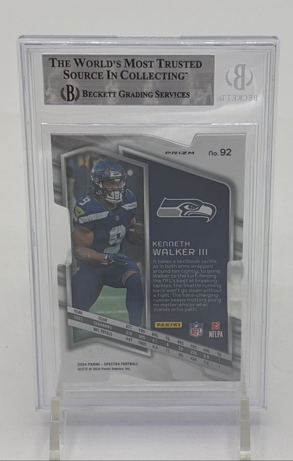 Back of 2024 Panini Spectra Kenneth Walker III Neon Blue Die-Cut card numbered 42 of 50 in BGS 9 holder, showing player statistics, biography, and Seattle Seahawks branding.