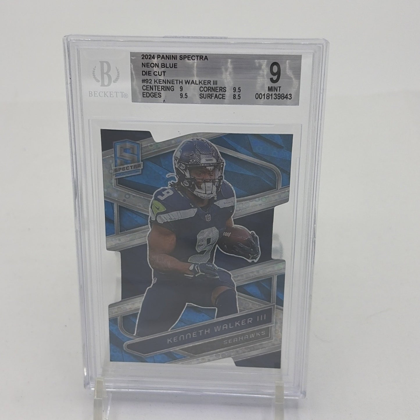 2024 Panini Spectra Kenneth Walker III Neon Blue Die-Cut card numbered 42 of 50, graded BGS 9 by Beckett, featuring Seattle Seahawks running back Kenneth Walker III. Limited to just 50 copies and featuring one of the NFL's most explosive runners, this is the kind of card that makes Seahawks collectors stop scrolling.