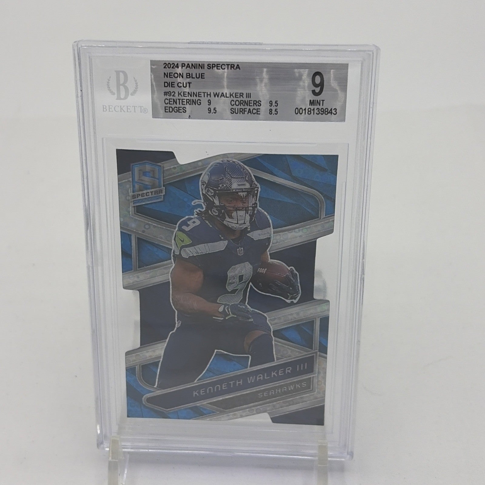 2024 Panini Spectra Kenneth Walker III Neon Blue Die-Cut card numbered 42 of 50, graded BGS 9 by Beckett, featuring Seattle Seahawks running back Kenneth Walker III. Limited to just 50 copies and featuring one of the NFL's most explosive runners, this is the kind of card that makes Seahawks collectors stop scrolling.