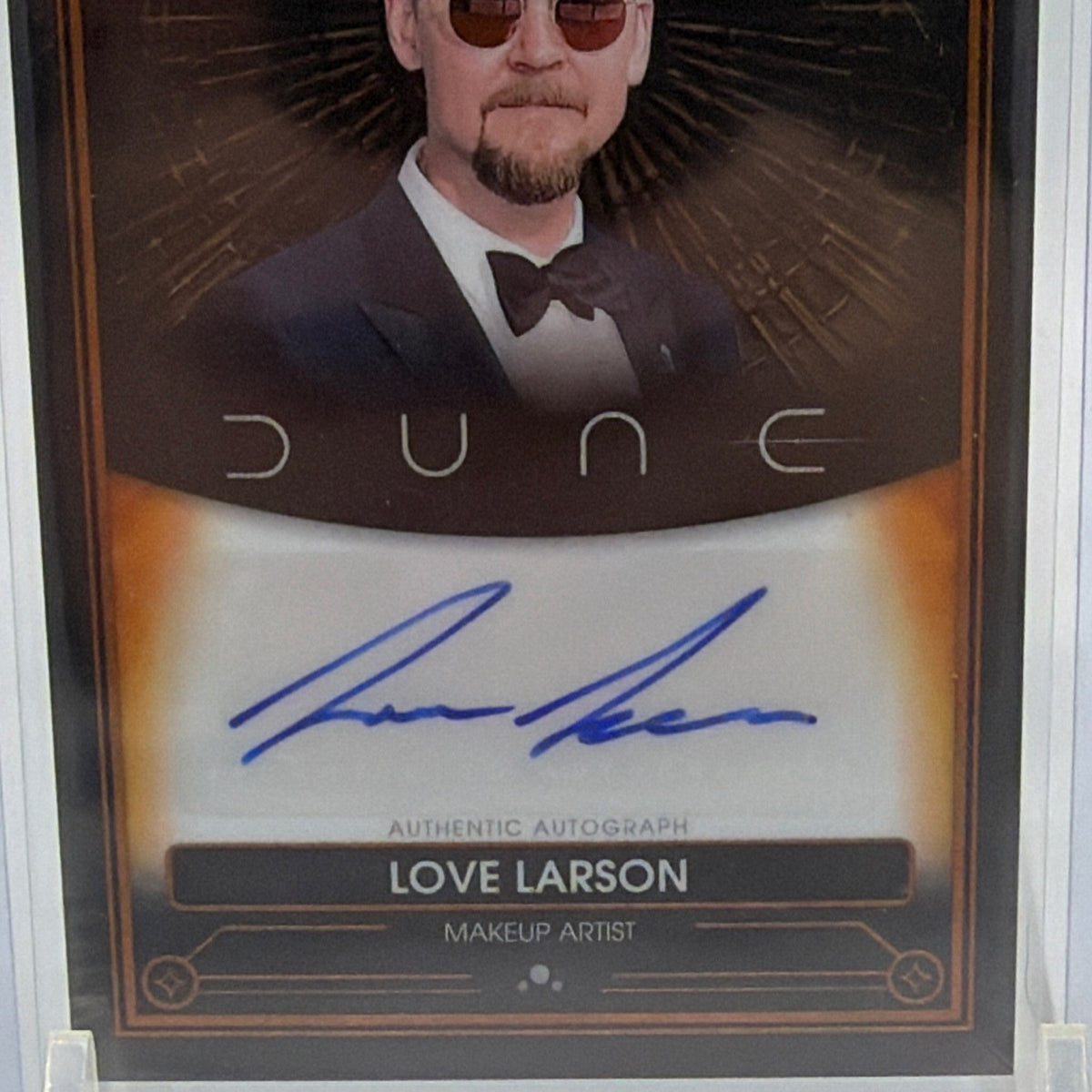 Close-up of blue autograph and gold-toned border on Love Larson Dune Chrome card