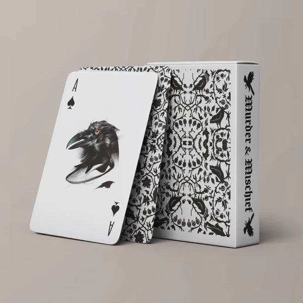 Be Like A Crow playing cards beside their illustrated black-and-white tuck box