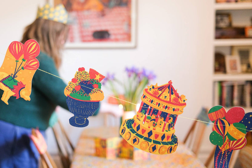 Colorful East End Press sewn garland displayed across a dining room for a birthday celebration