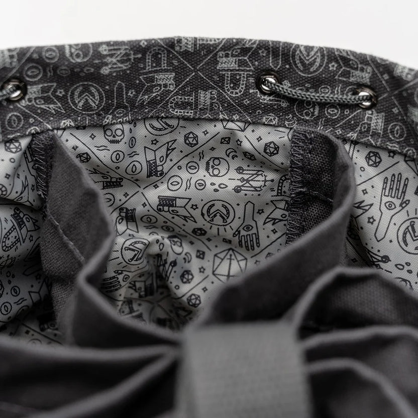 Close-up of interior patterning in Laura Bailey's dice bag of hording bag of holding.  Grey with blackline drawings of critical role icons and symbols of arcana