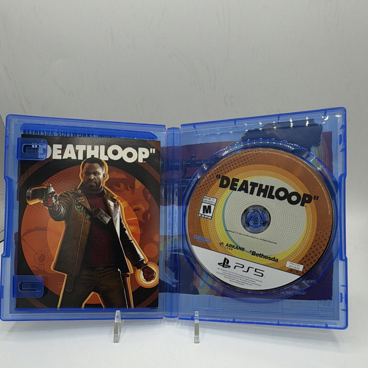 Open Deathloop PS5 case showing game disc and included printed insert