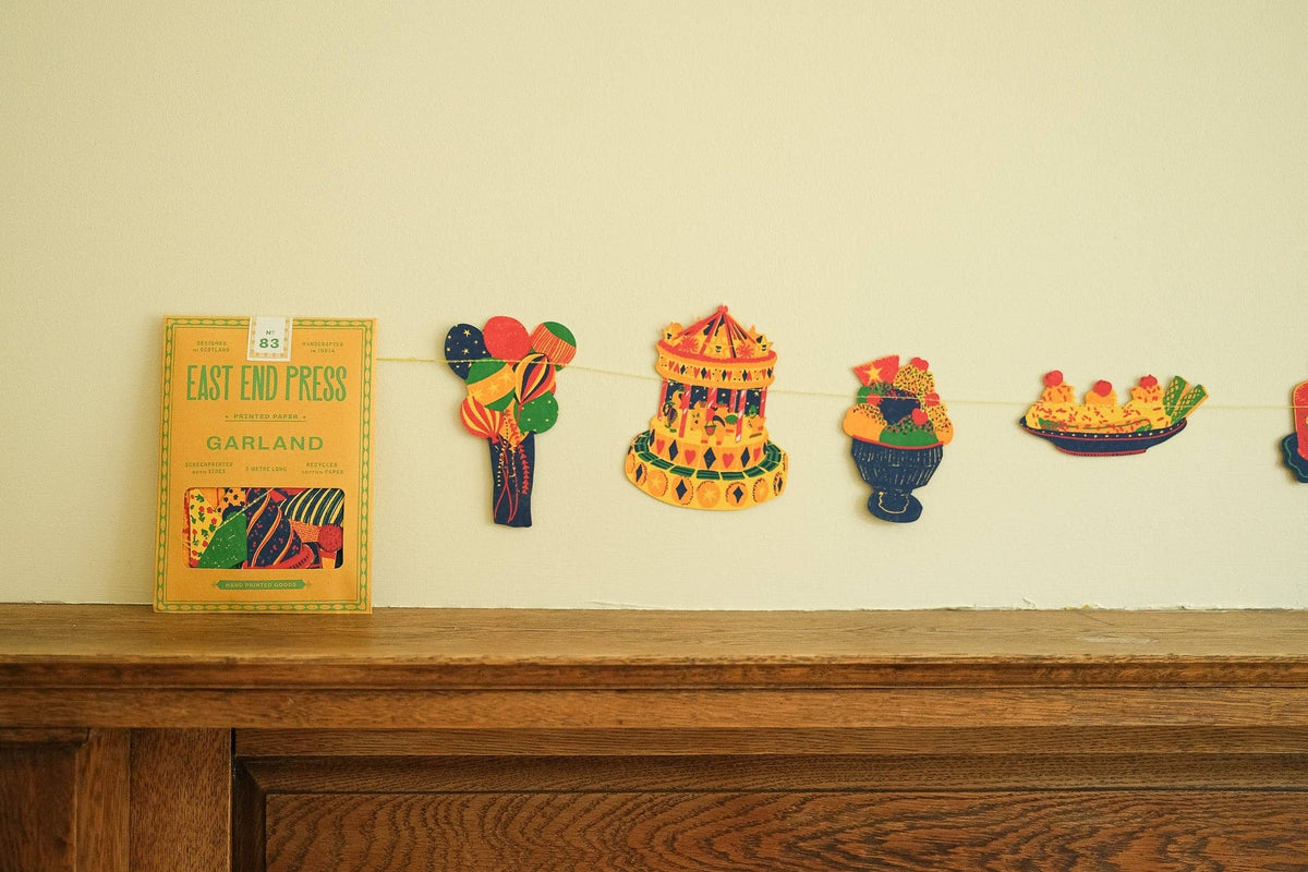 East End Press Birthday Party Garland displayed across a mantel with colorful birthday motifs