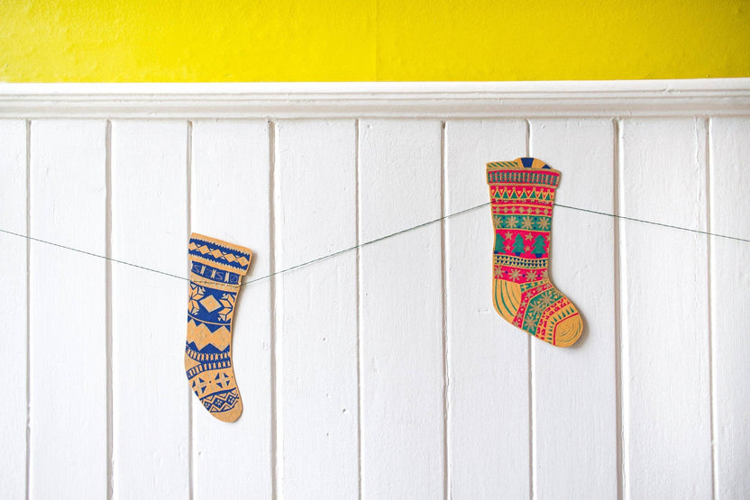 East End Press Festive Stockings Sewn Garland hanging across a white holiday mantel