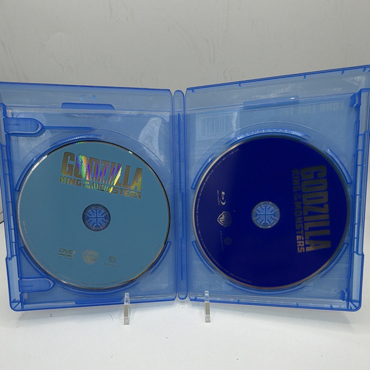 Open Godzilla: King of the Monsters case showing the included Blu-ray and DVD discs