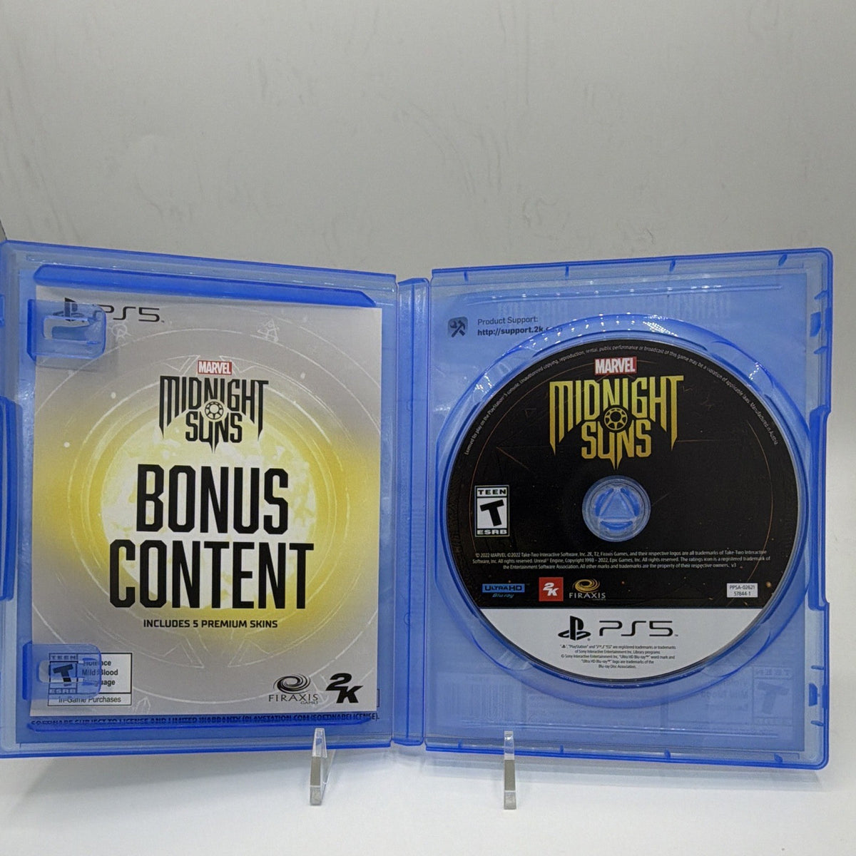 Open Marvel's Midnight Suns Enhanced Edition PS5 case with game disc and expired bonus-content insert