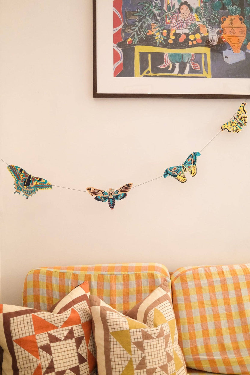 Hand printed East End Press moth garland decorating a cozy living room wall