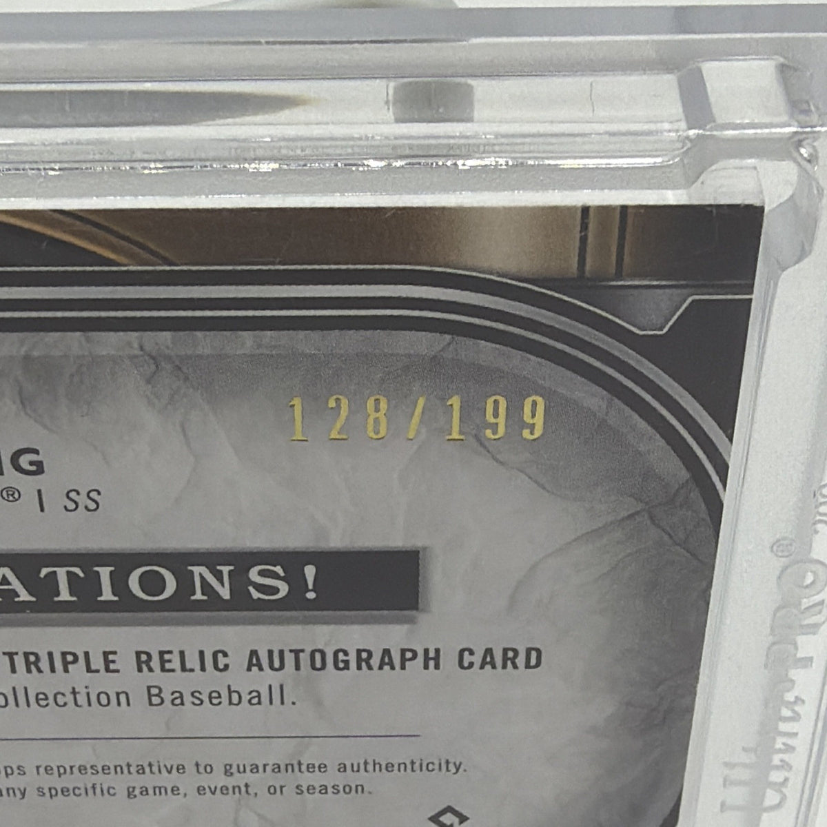 Close-up of the 128/199 serial number on Paul DeJong Museum Collection triple relic autograph