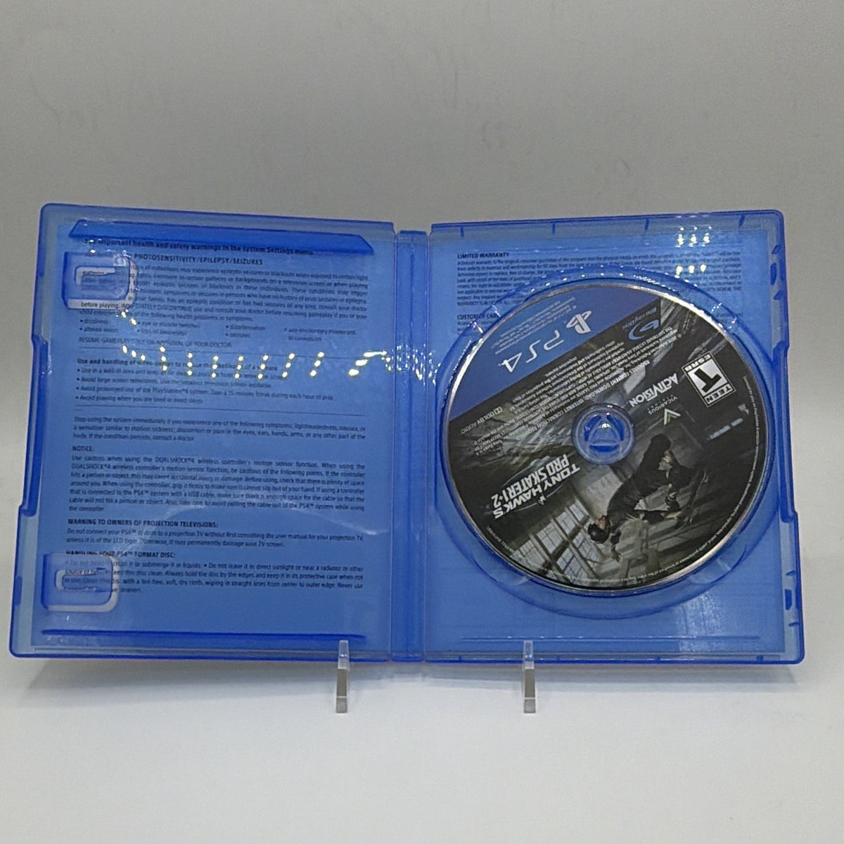 Open Tony Hawk's Pro Skater 1 + 2 PS4 case with game disc and no instruction booklet