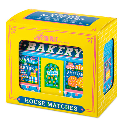 Bakery House matchbox, house-shaped safety matches, The Printed Peanut illustration, bakery shopfront matchbox design, pastry-themed gifts, foodie gift ideas, Archivist House Match collection, whimsical illustrated matchbox, UK-made safety matches, kitchen décor accessories, collectible matchbox art, Rogue & Rye curated gifts, colorful bakery artwork, artisan matchboxes.