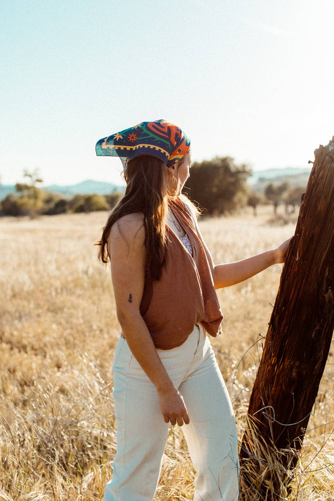 Endless Bloom bandana by Bandits Bandanas featuring four stylized orange foxes arranged in a circular floral pattern on a deep teal background with yellow flowers