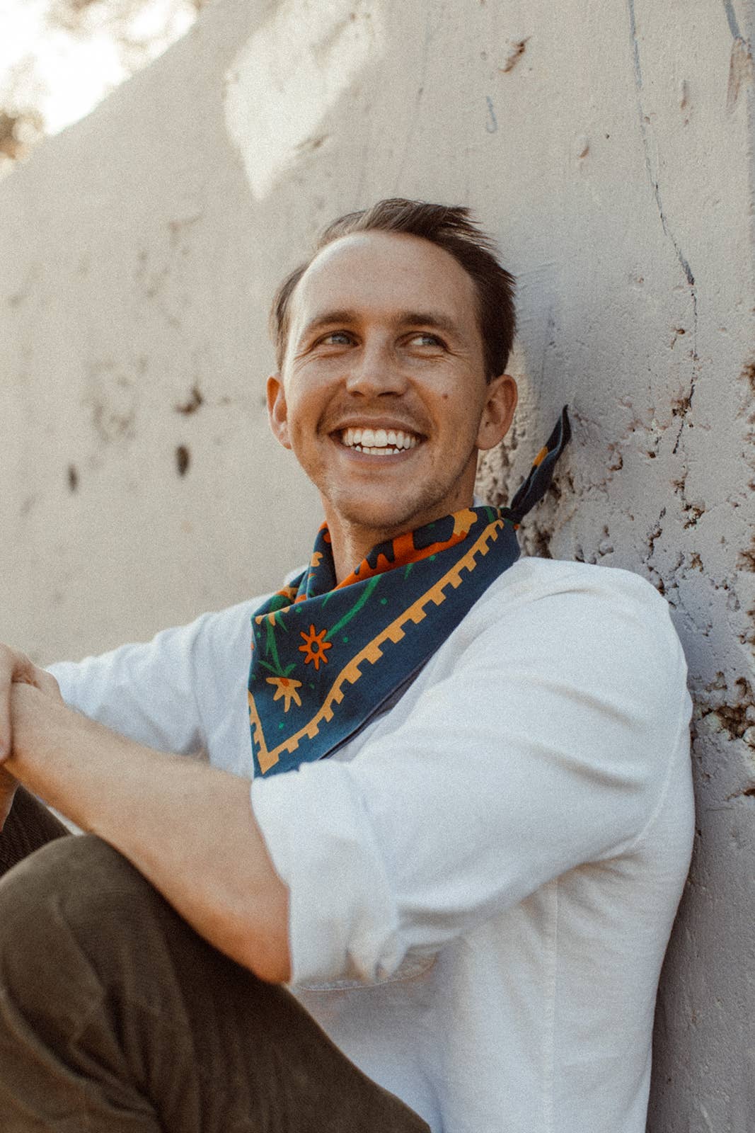 Endless Bloom bandana by Bandits Bandanas featuring four stylized orange foxes arranged in a circular floral pattern on a deep teal background with yellow flowers