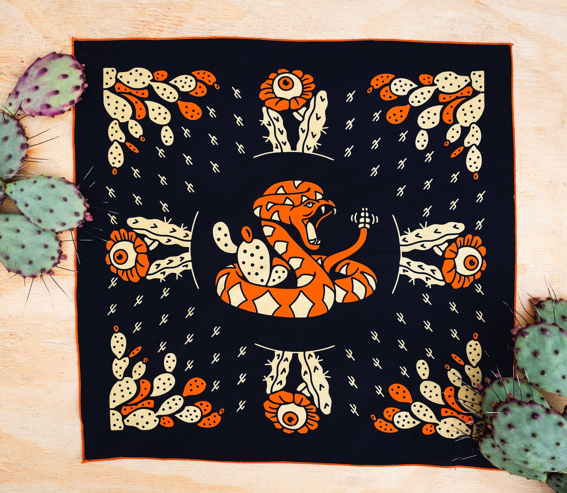 Bandits Cactus Dream bandana by Brothers Design Co. featuring a coiled rattlesnake surrounded by prickly pear cactus, cactus flowers, and Southwestern-inspired artwork.