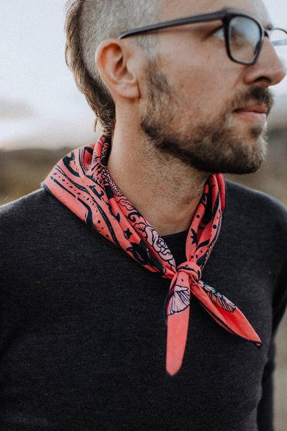 Model wearing the Bandits Rattle & Hiss bandana by Nuri Amanatullah tied as a rolled neck scarf with a black sweater.