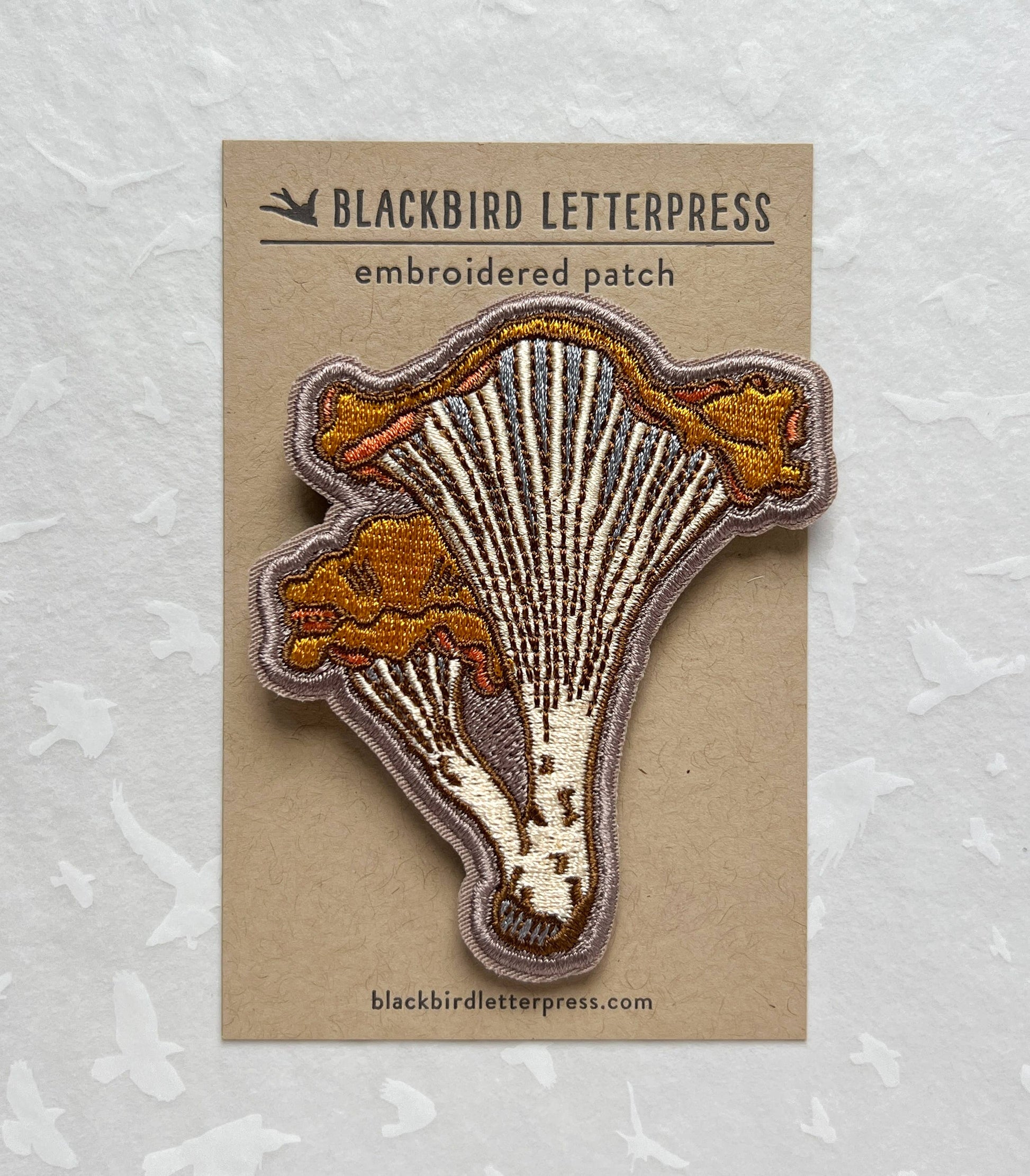 chanterelle mushroom patch, embroidered mushroom patch, golden mushroom iron-on, fungi sew-on patch, woodland embroidery patch, textured chanterelle applique, backpack mushroom patch, jean jacket patch, forager gift, artisan embroidered patch, blackbird letterpress patch, cottagecore mushroom accessory, nature lover patch, rogue & rye mushroom patch, embroidered chanterelle design