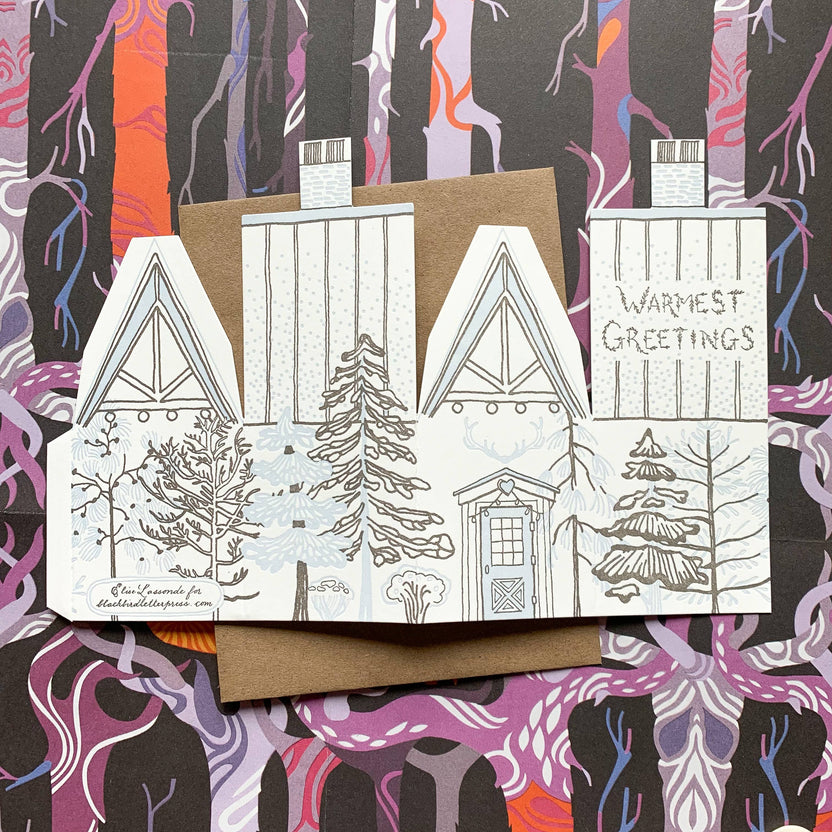 warmest greetings card, holiday cabin card, 3d house holiday card, winter cabin letterpress card, ice blue letterpress, forest brown letterpress, foldable holiday house card, buildable cabin card, die-cut Christmas card, miniature cabin card, artisan holiday stationery, Blackbird Letterpress holiday collection, Rogue & Rye holiday cards, winter greeting card, displayable paper craft card, Élise Lassonde illustration, A2 letterpress Christmas card