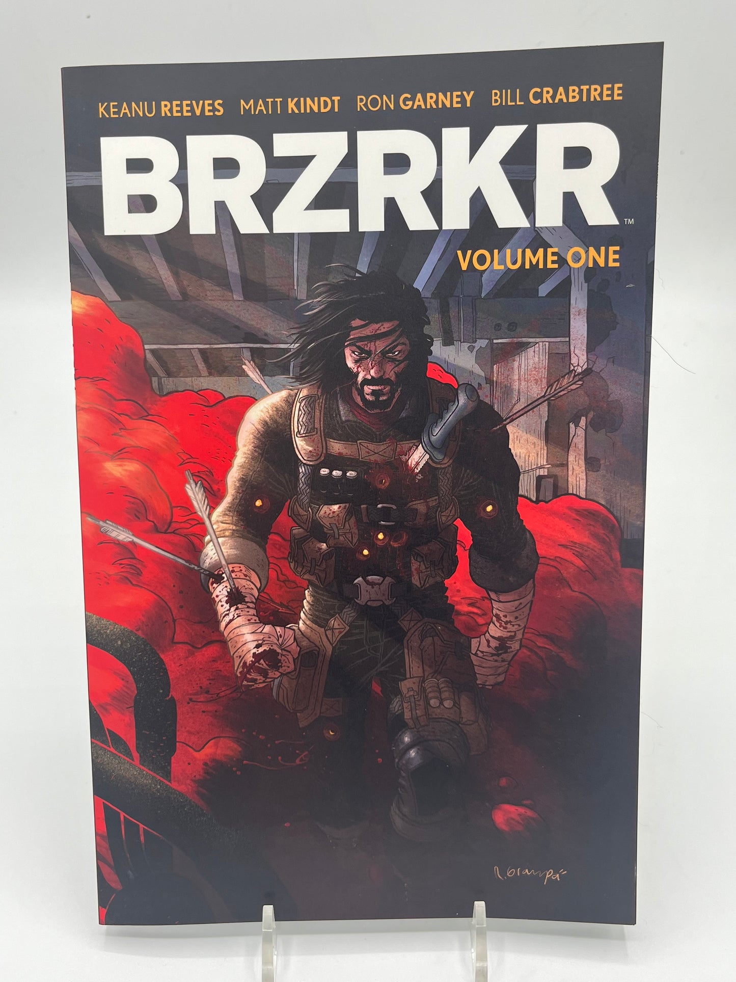 Cover of BRZRKR Volume One by Keanu Reeves, Matt Kindt, and Ron Garney featuring the immortal warrior Berserker walking through a battlefield surrounded by red smoke.
