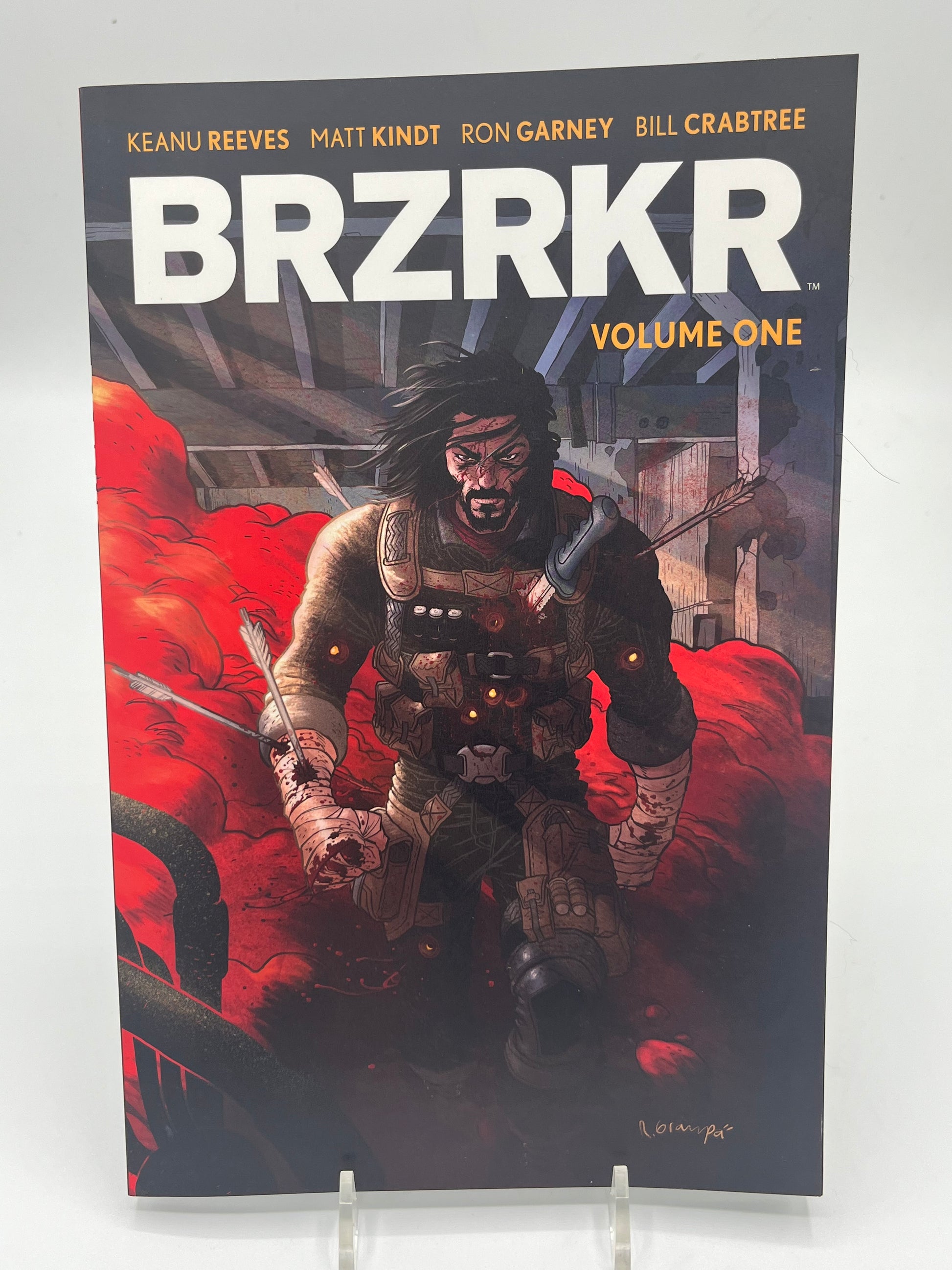 Cover of BRZRKR Volume One by Keanu Reeves, Matt Kindt, and Ron Garney featuring the immortal warrior Berserker walking through a battlefield surrounded by red smoke.