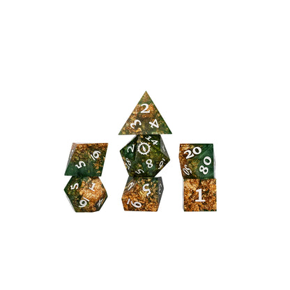 Aramán Seekers polyhedral dice grouped together, showing rich green resin and shimmering gold flakes