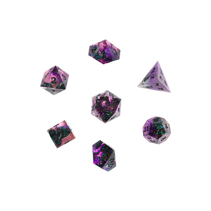 Close-up of the seven polyhedral dice included in the Critical Role Champion Dice Set inspired by Caduceus Clay. The sharp-edged resin dice feature swirling shades of pink, purple, and black with iridescent shimmer, green botanical inclusions, and dark green numbering. The custom d20 displays a mushroom icon, reflecting Caduceus's connection to nature, growth, and quiet wisdom.