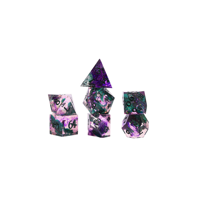 Seven sharp-edged polyhedral dice from the Critical Role Champion Dice Set inspired by Caduceus Clay arranged in a stacked display. The resin dice feature swirling pink, purple, and black tones with iridescent shimmer, green botanical inclusions, and dark green numbering. The set evokes the natural beauty, growth, and quiet strength associated with the beloved Mighty Nein cleric.