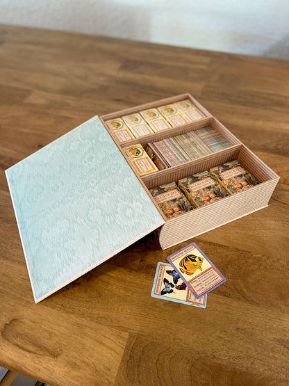 Ecologies card game organizer, faux book box card storage, vintage book game organizer, poker card storage box, ecological card game accessory, tuck box storage container, magnetic closure card holder, deck box for Ecologies games, antique map book box, card game collector case, stylish card deck organizer