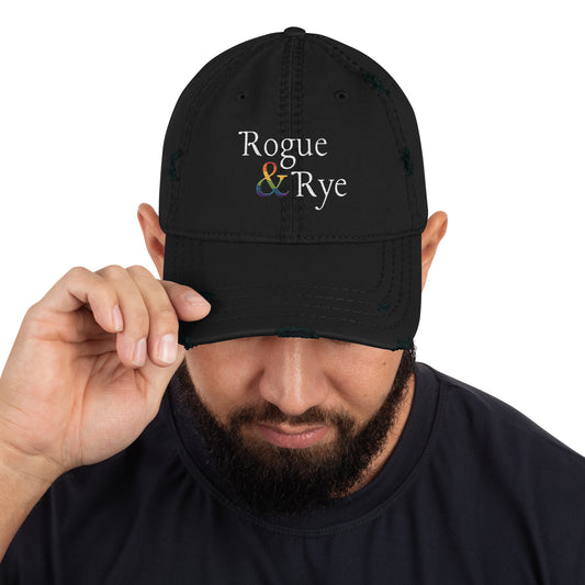 and well-worn pride cap, distressed pride hat, inclusive embroidered hat, rogue and rye lgbtq gear, queer and proud cap, lived-in pride cap, soft cotton twill hat, outright international donation, evolving identity hat, rogue and rye pride collection, gender inclusive pride wear, adjustable distressed cap, embroidered and message, everyday queer pride gear, unstructured pride cap, pride fashion hat, lgbtq supportive cap