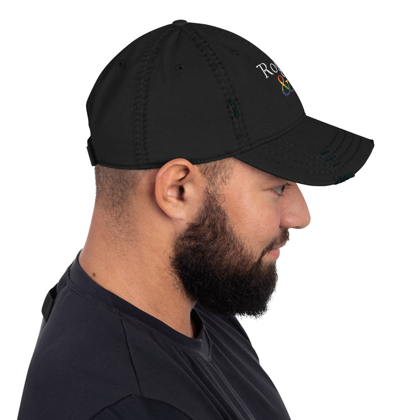 and well-worn pride cap, distressed pride hat, inclusive embroidered hat, rogue and rye lgbtq gear, queer and proud cap, lived-in pride cap, soft cotton twill hat, outright international donation, evolving identity hat, rogue and rye pride collection, gender inclusive pride wear, adjustable distressed cap, embroidered and message, everyday queer pride gear, unstructured pride cap, pride fashion hat, lgbtq supportive cap
